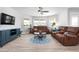 Cozy living room featuring lots of natural light, hardwood floors, ceiling fan, and comfortable leather seating at 915 Citrus Rd, Venice, FL 34293
