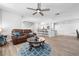 Open-concept living room with wood floors, a ceiling fan and a view of the kitchen bar at 915 Citrus Rd, Venice, FL 34293