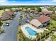 Aerial view of community featuring a swimming pool, landscaping, parking, and beautiful condo buildings at 925 Capri Isles Blvd # 4, Venice, FL 34292