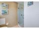 Bathroom featuring a tiled walk-in shower with glass door, toilet, and neutral decor at 925 Capri Isles Blvd # 4, Venice, FL 34292
