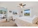 Comfortable bedroom with neutral carpet, dresser, large window with outdoor view, and doorway to living area at 925 Capri Isles Blvd # 4, Venice, FL 34292