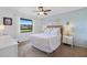 Cozy bedroom featuring a ceiling fan, a comfortable bed with decorative pillows, and natural light from the window at 925 Capri Isles Blvd # 4, Venice, FL 34292