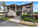 Exterior of a two-story condo with stone accents, balcony, tropical landscaping, and a well-maintained walkway at 925 Capri Isles Blvd # 4, Venice, FL 34292