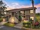 Exterior of a two-story condo with stone accents, balcony, tropical landscaping, and a well-maintained walkway at 925 Capri Isles Blvd # 4, Venice, FL 34292