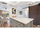 Bright kitchen island with white marble countertop and gray cabinetry with barn door entrance at 925 Capri Isles Blvd # 4, Venice, FL 34292