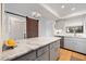 Modern kitchen featuring a stylish sliding barn door, white cabinets, and a marble island at 925 Capri Isles Blvd # 4, Venice, FL 34292