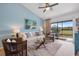 Bright living room with blue walls, white couch, and sliding doors to a balcony overlooking lush greenery at 925 Capri Isles Blvd # 4, Venice, FL 34292