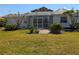 A serene backyard featuring a screened-in porch surrounded by lush landscaping at 926 Inlet Cir, Venice, FL 34285