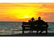 Couple watching a romantic sunset over the ocean while sitting on a bench at 926 Inlet Cir, Venice, FL 34285