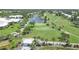 Scenic aerial view of a lush golf course and pond, surrounded by trees and residential properties at 934 Wexford Blvd # 934, Venice, FL 34293