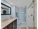Well-lit bathroom features stylish vanity, sleek glass-door shower, and convenient in-unit washer and dryer at 934 Wexford Blvd # 934, Venice, FL 34293