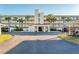 Spacious condo building featuring a grand entrance, covered parking, and tropical landscaping with swaying palm trees at 934 Wexford Blvd # 934, Venice, FL 34293