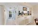 Bright, open kitchen featuring a breakfast bar, white cabinets, stainless steel appliances, and tiled backsplash at 934 Wexford Blvd # 934, Venice, FL 34293