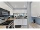 Bright, modern kitchen features white cabinets, stainless steel appliances and granite countertops at 934 Wexford Blvd # 934, Venice, FL 34293