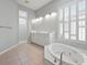 Bright bathroom featuring a tub, double vanity, and large window with plantation shutters at 1028 Grouse Way, Venice, FL 34285