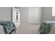 A bedroom featuring two beds, bi-fold doors to closet, and a doorway to another room at 1028 Grouse Way, Venice, FL 34285
