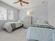 A bright bedroom featuring two beds, ceiling fan and a bright window at 1028 Grouse Way, Venice, FL 34285