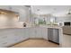Modern kitchen with white cabinetry, stainless steel appliances, and views into the living area at 1028 Grouse Way, Venice, FL 34285