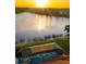 Aerial view of the home's pool and lake with a sunset background at 109 Montelluna Dr, North Venice, FL 34275