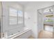 Beautiful bathroom featuring a soaking tub, white tile, and window with plantation shutters at 109 Montelluna Dr, North Venice, FL 34275
