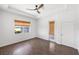 Bright bedroom with wood floor, tray ceiling, ceiling fan, and window overlooking the water at 109 Montelluna Dr, North Venice, FL 34275
