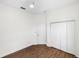 Bright bedroom featuring wood floors, white walls, a ceiling fan, and a closet for storage at 109 Montelluna Dr, North Venice, FL 34275