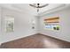 Sunlit bedroom with wood floors, ceiling fan, and a picturesque water view at 109 Montelluna Dr, North Venice, FL 34275
