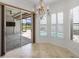 Bright breakfast nook with chandelier, shutters, tile floor, and access to the outdoor lanai and pool at 109 Montelluna Dr, North Venice, FL 34275