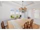 Formal dining room with large table, decorative chandelier, and beautiful arched windows with natural light at 109 Montelluna Dr, North Venice, FL 34275
