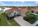 Beautiful waterfront home with a tile roof, well-manicured landscaping, and a brick paver driveway at 109 Montelluna Dr, North Venice, FL 34275