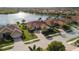 Beautiful home with a well-manicured lawn, brick driveway, lush landscaping, and a gray tiled roof at 109 Montelluna Dr, North Venice, FL 34275