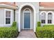 Inviting front entrance with a classic blue door, decorative trim, and manicured shrubs at 109 Montelluna Dr, North Venice, FL 34275