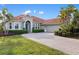 Charming home with a red tile roof, manicured landscaping, and a paved driveway at 109 Montelluna Dr, North Venice, FL 34275