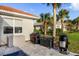 Outdoor patio features a grill, lush landscaping, and a view of a neighboring home at 109 Montelluna Dr, North Venice, FL 34275