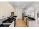 Well-lit kitchen featuring sleek black countertops, stainless steel appliances, and ample cabinet space at 109 Montelluna Dr, North Venice, FL 34275