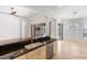 Open kitchen with dark granite countertops and stainless appliances, slider to pool and patio at 109 Montelluna Dr, North Venice, FL 34275