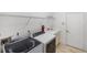 Functional laundry room with washer, dryer, utility sink, and wire shelving at 109 Montelluna Dr, North Venice, FL 34275
