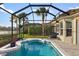 Screened-in pool features a view of the lake, tiled deck, and comfortable lounge chair at 109 Montelluna Dr, North Venice, FL 34275