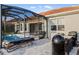 Outdoor pool features patio seating, lounge chairs, and a grill, all inside a screened enclosure at 109 Montelluna Dr, North Venice, FL 34275