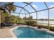 Screened-in pool features a beautiful lake view, tiled deck, and comfortable lounge chairs at 109 Montelluna Dr, North Venice, FL 34275