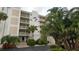Bahia Mar condo building featuring multi-level balconies and lush tropical landscaping at 1100 Tarpon Center Dr # 102B, Venice, FL 34285