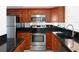 Kitchen featuring stainless steel appliances and dark countertops with wood cabinets at 1100 Tarpon Center Dr # 102B, Venice, FL 34285