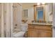 Bathroom featuring a vanity with a granite countertop, wood cabinets, and a tub shower at 1130 Bird Bay Way # 184, Venice, FL 34285