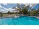 Relax and enjoy the community pool with lounge chairs and shady trees at 1130 Bird Bay Way # 184, Venice, FL 34285