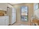 Clean kitchen with white appliances and ample cabinet space next to a bright window at 1130 Bird Bay Way # 184, Venice, FL 34285