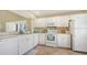 Bright, clean kitchen with white appliances, plenty of counter space, and tile flooring at 1130 Bird Bay Way # 184, Venice, FL 34285