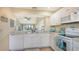 Open kitchen featuring white appliances and cabinetry with a view to dining and living areas at 1130 Bird Bay Way # 184, Venice, FL 34285