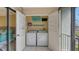 A laundry closet with a washer and dryer, with shelf storage on lanai at 1130 Bird Bay Way # 184, Venice, FL 34285