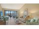 Bright living room with tile flooring, a comfortable seating area, and access to a screened lanai with serene lake views at 1130 Bird Bay Way # 184, Venice, FL 34285