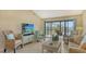 Bright living room with comfortable seating, a large TV, and access to an outdoor patio at 1130 Bird Bay Way # 184, Venice, FL 34285